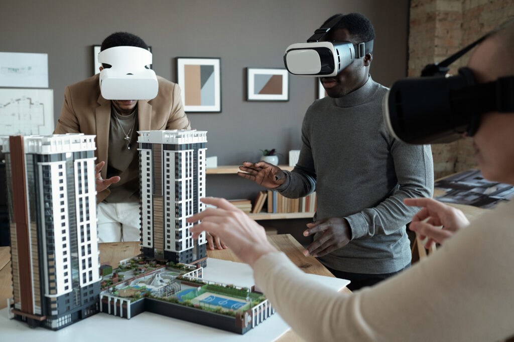 group of architects in vr headsets standing around table with house layout